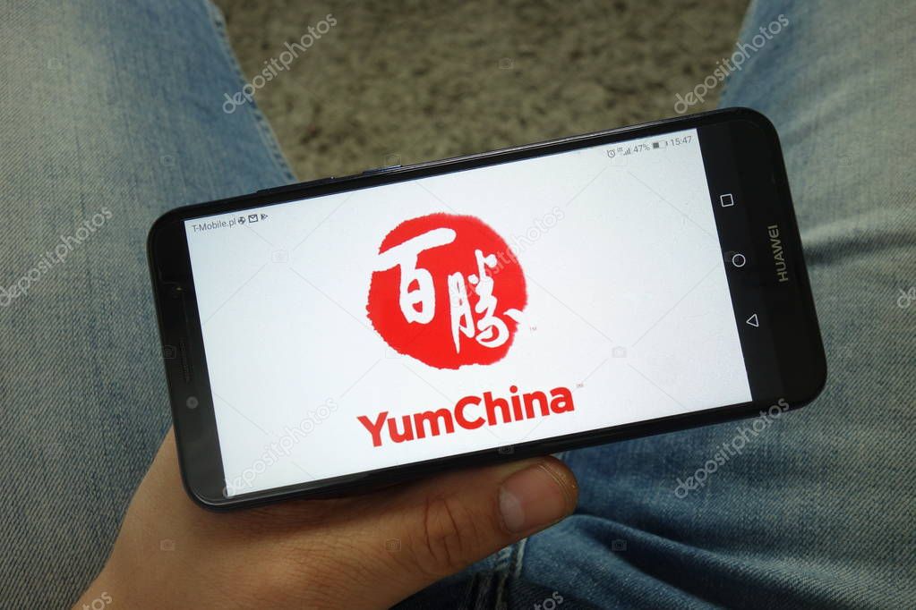KONSKIE, POLAND - April 13, 2019: Man holding smartphone with Yum China restaurant company logo