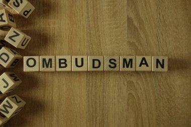 Ombudsman word from wooden blocks on desk clipart