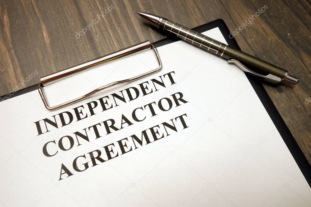 Clipboard with independent contractor agreement and pen on desk