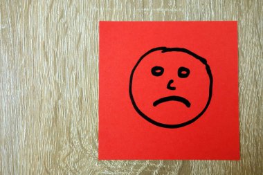 Kırmızı etiket üzerine çizilmiş üzgün mutsuz yüz