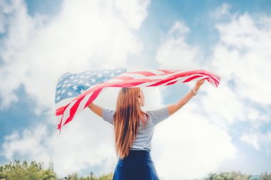 Amerikan bayrağı vatansever tatil ile duran mutlu kadın. ABD kutlamak 4 Temmuz