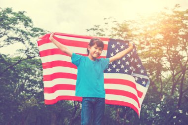 Mutlu bir çocukluk ABD kutlamak Amerikan bayrağı ile 4 Temmuz ile çalışan küçük çocuk