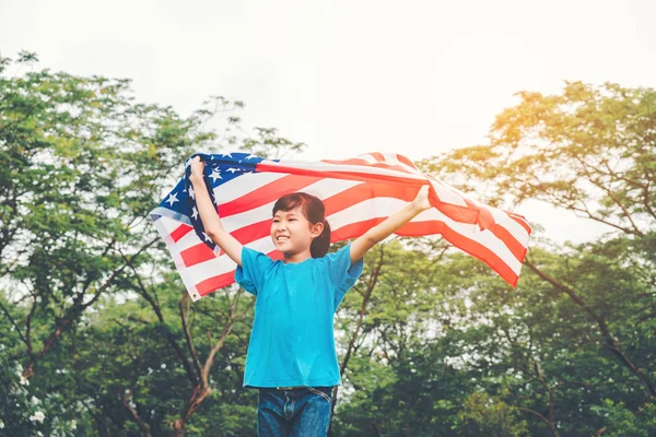 Mutlu bir çocukluk ABD kutlamak Amerikan bayrağı ile 4 Temmuz ile çalışan küçük çocuk