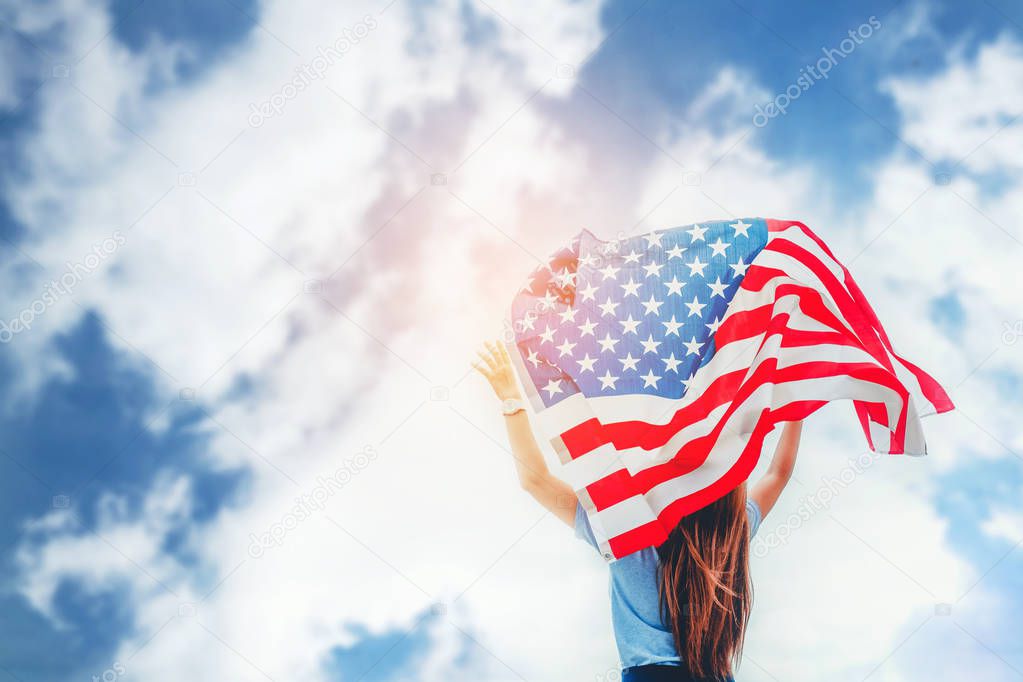 Happy woman standing with American flag Patriotic holiday.USA celebrate 4th of July