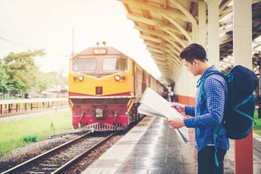 Turist backpacker tren istasyonunda seyahat etmek harita kullanarak