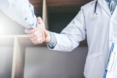 Kendine güvenen Doktor hastanede hasta konuşma ile el sıkışan