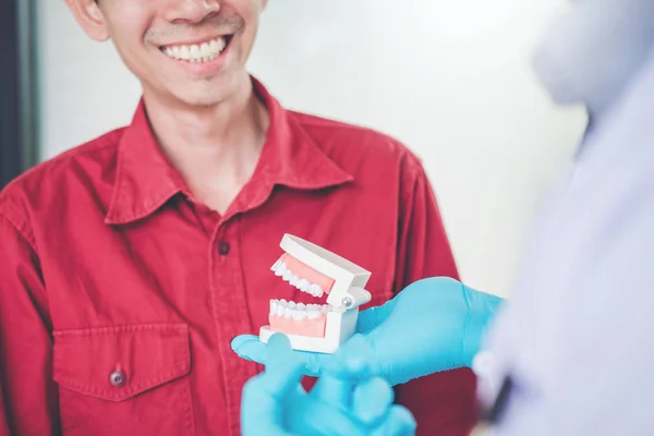 Tandarts Praten Met Glimlachen Mannelijke Patiënt Weergegeven Gebit Tandheelkundige Kantoor — Stockfoto