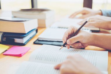 Yüksek okul veya üniversite öğrencileri eğitim ve birlikte kitaplıkta okuma