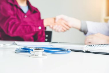 Kendine güvenen Doktor hastanede hasta konuşma ile el sıkışan