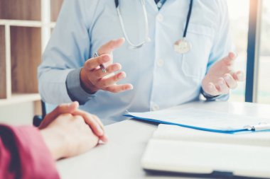 Doktorlar ve hastalar oturup konuşmak. Masada hastane penceresinde yakınındaki