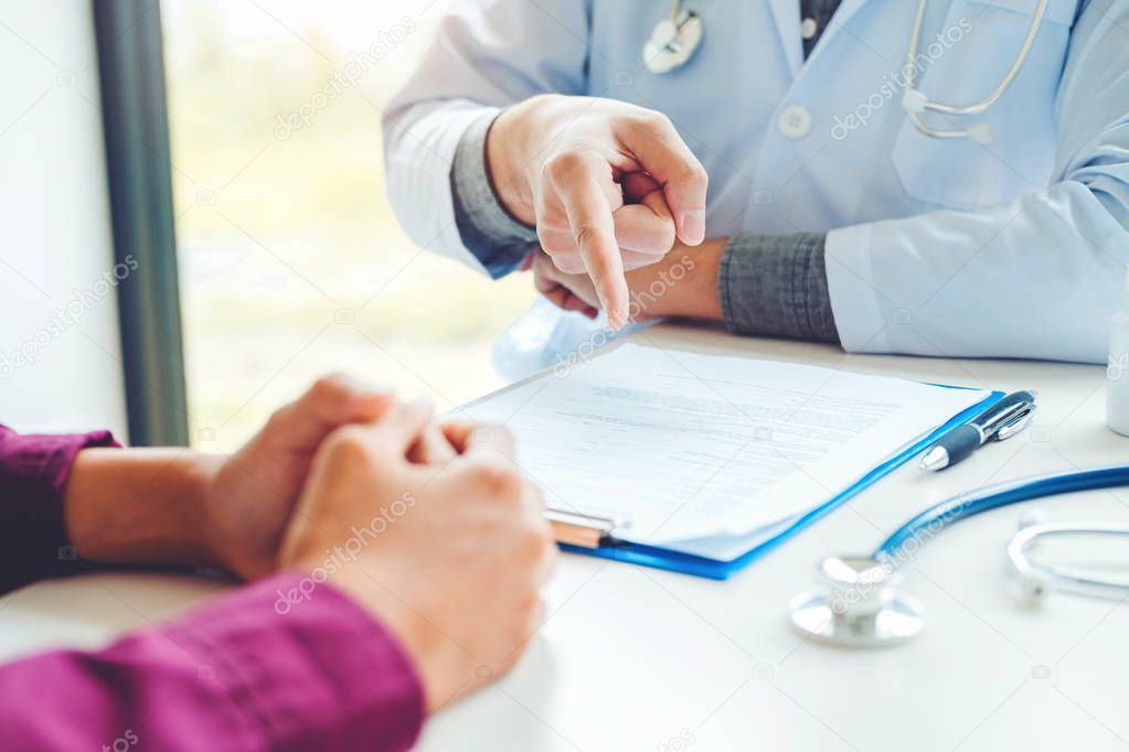 Doctors and patients sit and talk. At the table near the window in the hospital