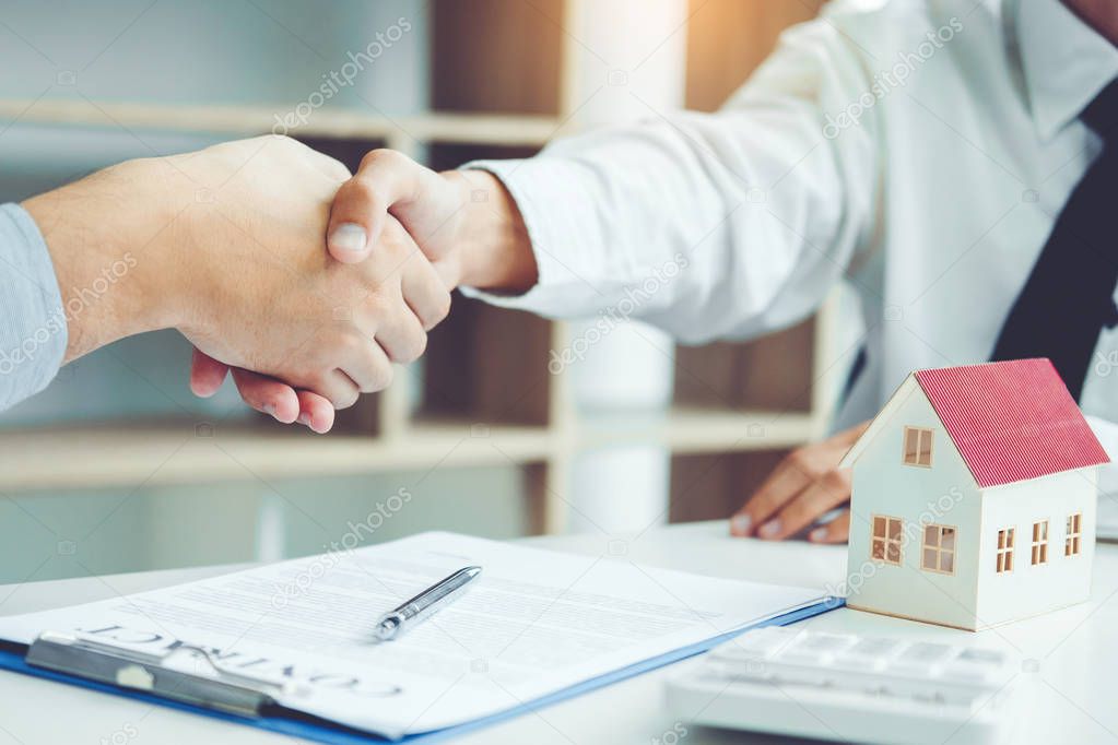 Business people negotiating a contract handshake between two colleagues