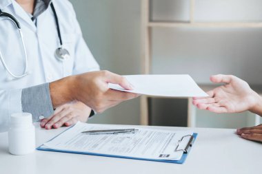 Doktor veya tanı yazma ve tıbbi reçete için Bayan hasta veren doktor