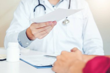 Doktor veya tanı yazma ve tıbbi reçete için Bayan hasta veren doktor
