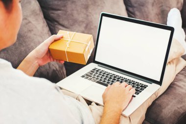 Başlangıç girişimci küçük işletme sahibi Online iş satıcı ambalaj ve teslimat kavramı çalışma ile dizüstü bilgisayar boş perde vasıl ev, Genç adam