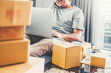 Telefonunu evde müşteriler, Online iş satıcı ambalaj ve teslim kavramı ile konuşurken başlangıç girişimci küçük işletme sahibi genç adam