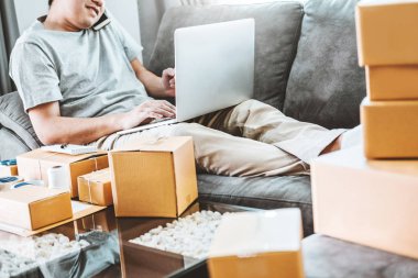 Telefonunu evde müşteriler, Online iş satıcı ambalaj ve teslim kavramı ile konuşurken başlangıç girişimci küçük işletme sahibi genç adam