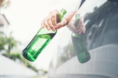 Sarhoş adam şişe bira tehlikeli sarhoş sürüş kavramı holding yolda bir araba