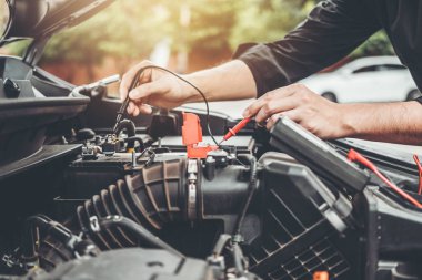 Otomatik mekanik çalışma garaj teknisyen araba oto tamir servis ve bakım araba pil kontrolü mekanik çalışan eller.