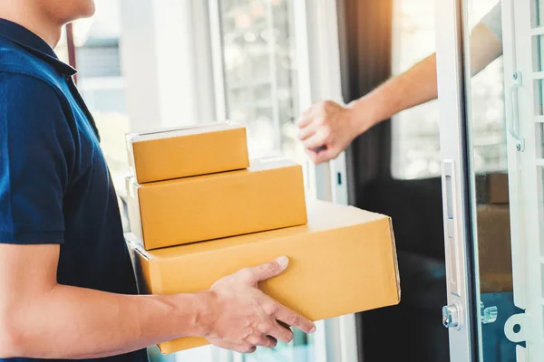 Asian man Delivery service with boxes in hands standing in front of Customer\'s house doors