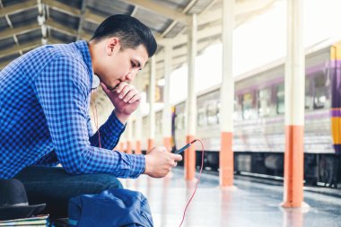 Seyahat telefon dinleme müzik telefonu kullanan adam ve tren istasyonunda