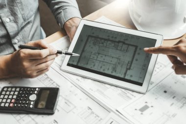 Toplantı ve dijital tablet mimari proje için kullanma ve işyeri üzerinde mühendislik ortak çalışma mühendisi