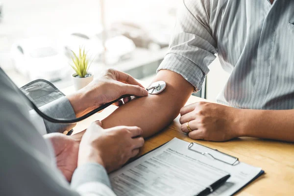 Doctor Measuring arterial blood pressure with man patient on arm — Stock Photo, Image