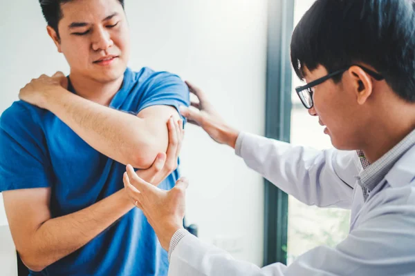 Médico físico consultando con el paciente Sobre el dolor muscular del codo —  Fotos de Stock