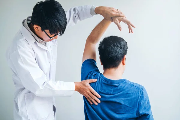 Fizyczne lekarz konsultacji z pacjentem o ramię muscule p — Zdjęcie stockowe