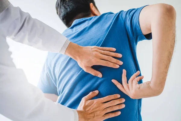 Physical Doctor consulting with patient about Back problems Phys