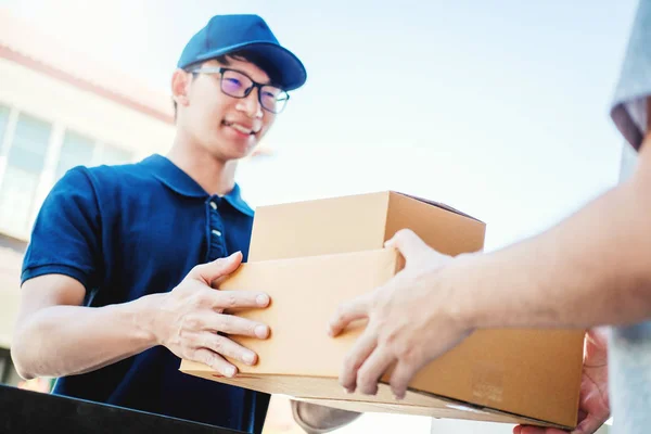 Delivery concept Asian man hand accepteren van een levering dozen uit — Stockfoto