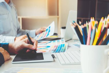 İki grafik tasarımcı grafik tablet ve renk palett üzerinde çizim