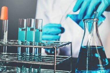 Bilim adamı bilimsel experim sırasında araçları tutarak ekipman ile