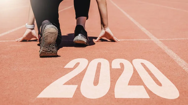 2020 Newyear, idrottsman kvinna börjar på linjen och börjar köra — Stockfoto