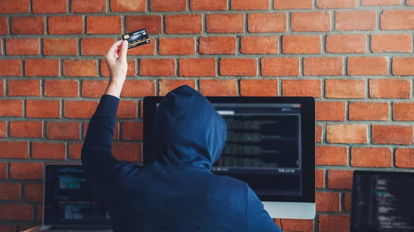 Farlig hætteklædte Hacker ved hjælp af kreditkort skrive dårlige data i c - Stock-foto