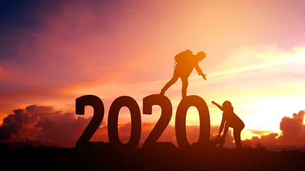 Le escursioni di coppia si aiutano a vicenda silhouette nel 2020 nuovo anno — Foto Stock