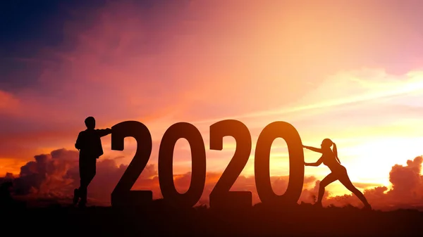 2020 NewYear paar probeert te duwen nummer van 2020 gelukkig Nieuwjaar — Stockfoto