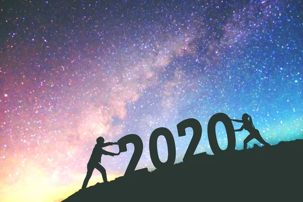 2020 Casal Newyear tenta empurrar o número de 2020 Feliz ano novo — Fotografia de Stock