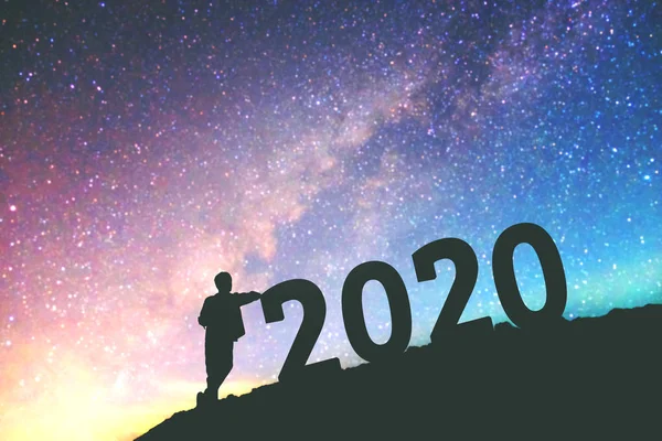 Silhouet jonge man gelukkig voor 2020 Nieuwjaar achtergrond op de — Stockfoto