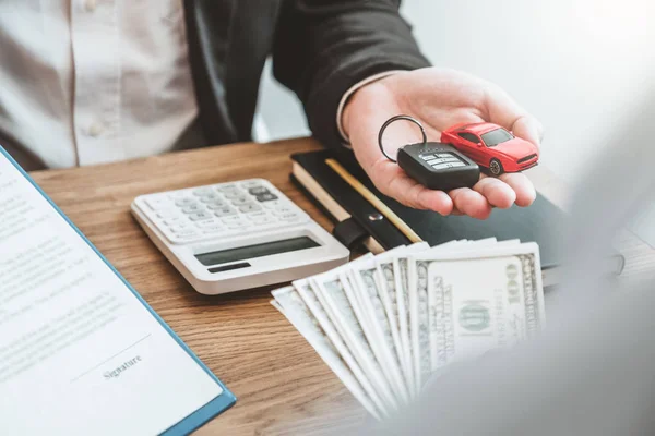 Agente de la venta que da llave del coche al cliente y firma contrato del acuerdo — Foto de Stock