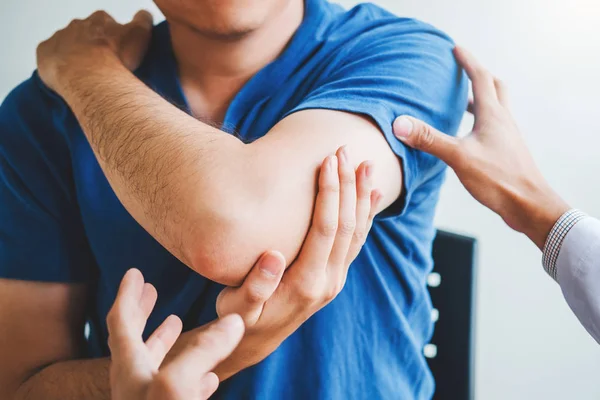 Médico físico consultando con el paciente Sobre el dolor muscular del codo —  Fotos de Stock