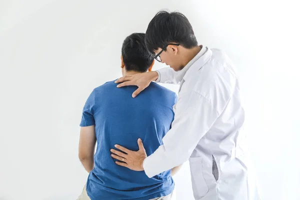Médico físico consultando con el paciente sobre problemas de espalda Phys Imagen de stock