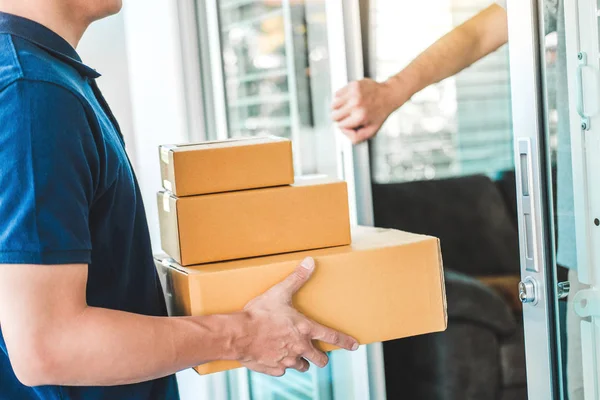 Leverans asiatisk man service med lådor i händerna stående framför — Stockfoto