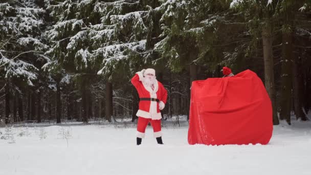 Weihnachtsmann mit riesigem Sack voller Geschenke läuft im Wald.