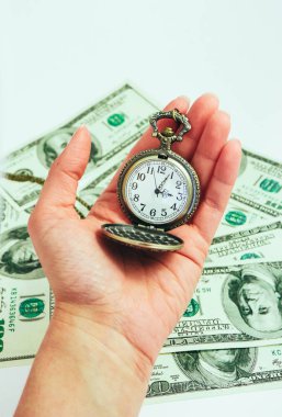 Bir el, bir arka plan üzerinde Amerikan Doları banknot para eski cep saati tutun. Zaman ve iş kavramı.