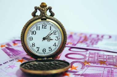 Euro banknot para, makro görünümü ile eski cep saati. Zaman ve iş kavramı.