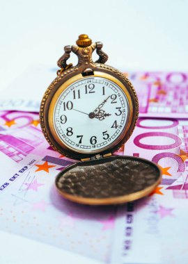 Euro banknot para, makro görünümü ile eski cep saati. Zaman ve iş kavramı.