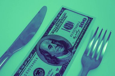 Bıçak ve çatal ile bir tablo üzerinde döşeme 100 Amerikan Doları o banknot. Pahallı Restoran gıda kavramı.