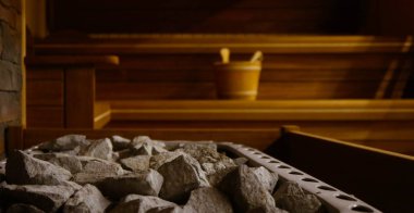 Taş ile dolu bir Isıtma pot ile ahşap bathhouse, yakın. Ahşap sauna iç ekipmanları, kömürleri, kepçe, kova.