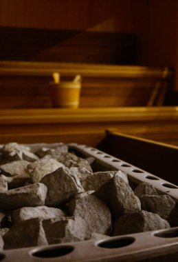 Taş ile dolu bir Isıtma pot ile ahşap bathhouse, yakın. Ahşap sauna iç ekipmanları, kömürleri, kepçe, kova.